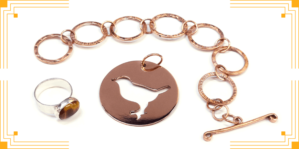 Picture of metalsmithing jewellery samples, a bronze pendant, a ring and a chain